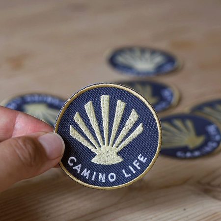 Camino-rygsaek-maerke-muslingeskal-broderet-badge-camino-frances-camino-de-santiago-strygebagside-saint-james-way-pilgrim-trekking-indigo-blaa-rundt-900x900px