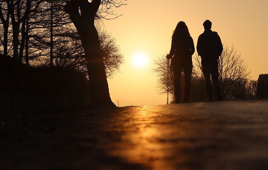 solopgang-paa-camoenoen-busene-vandring-asfalt-rygsaek